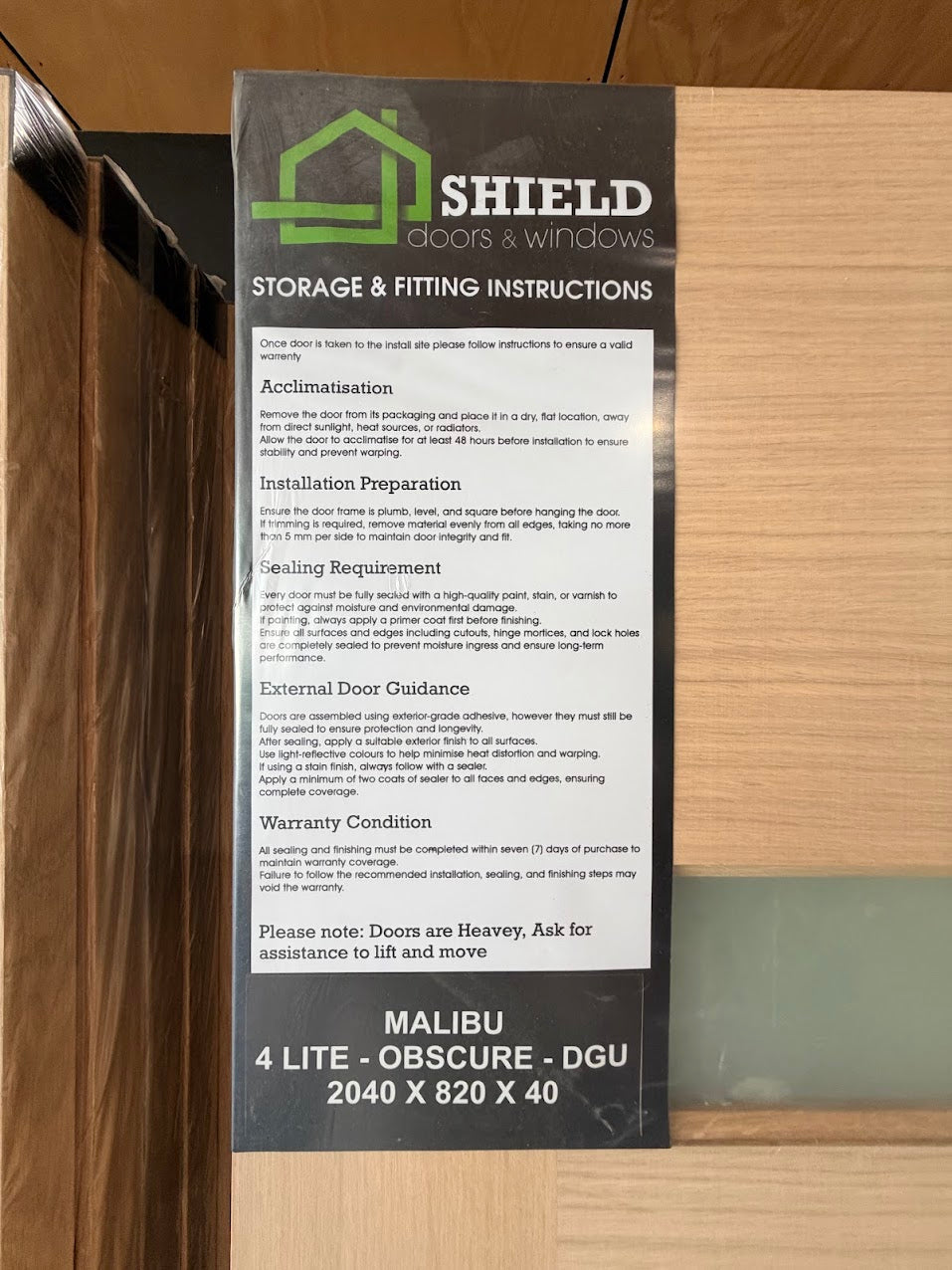 Shield doors and windows storage and fitting instructions on a wooden surface of 4_Panel_Malibu_Double_Glazed_Entry_door_product