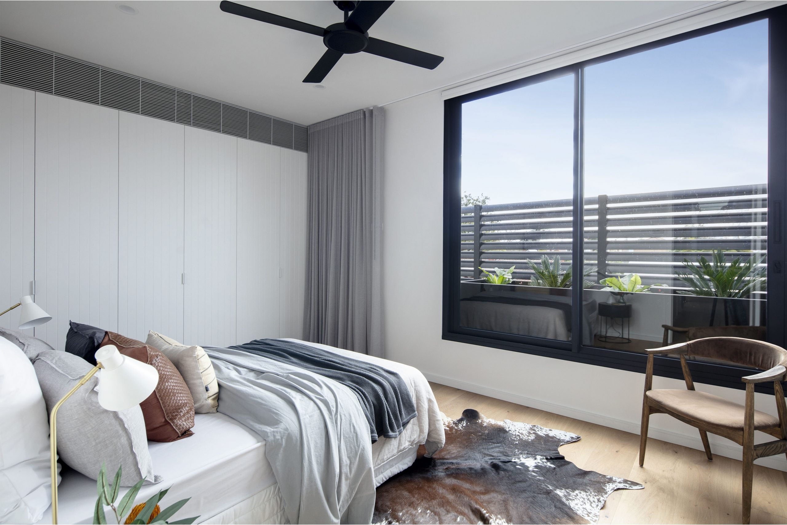 A bedroom with a bed, a chair and a window
