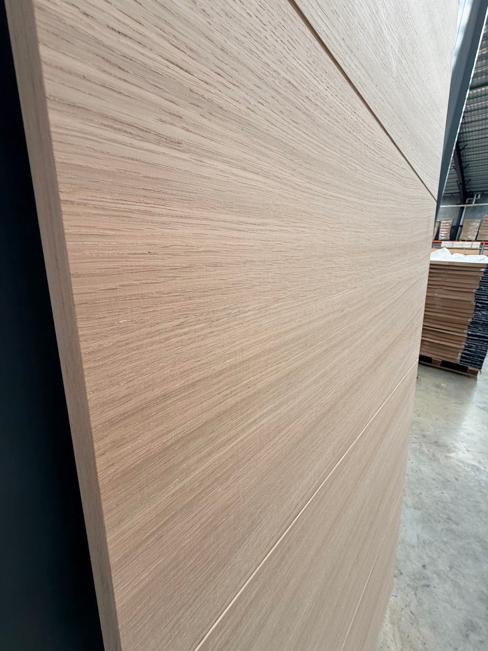 Close-up of a Internal white oak wooden door with a blurred warehouse background
