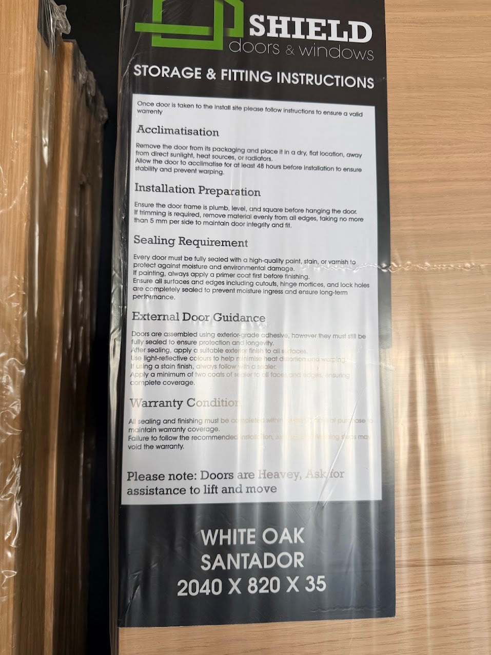Storage and fitting instructions for a Internal white oak wooden door on a wooden surface by shield door and window